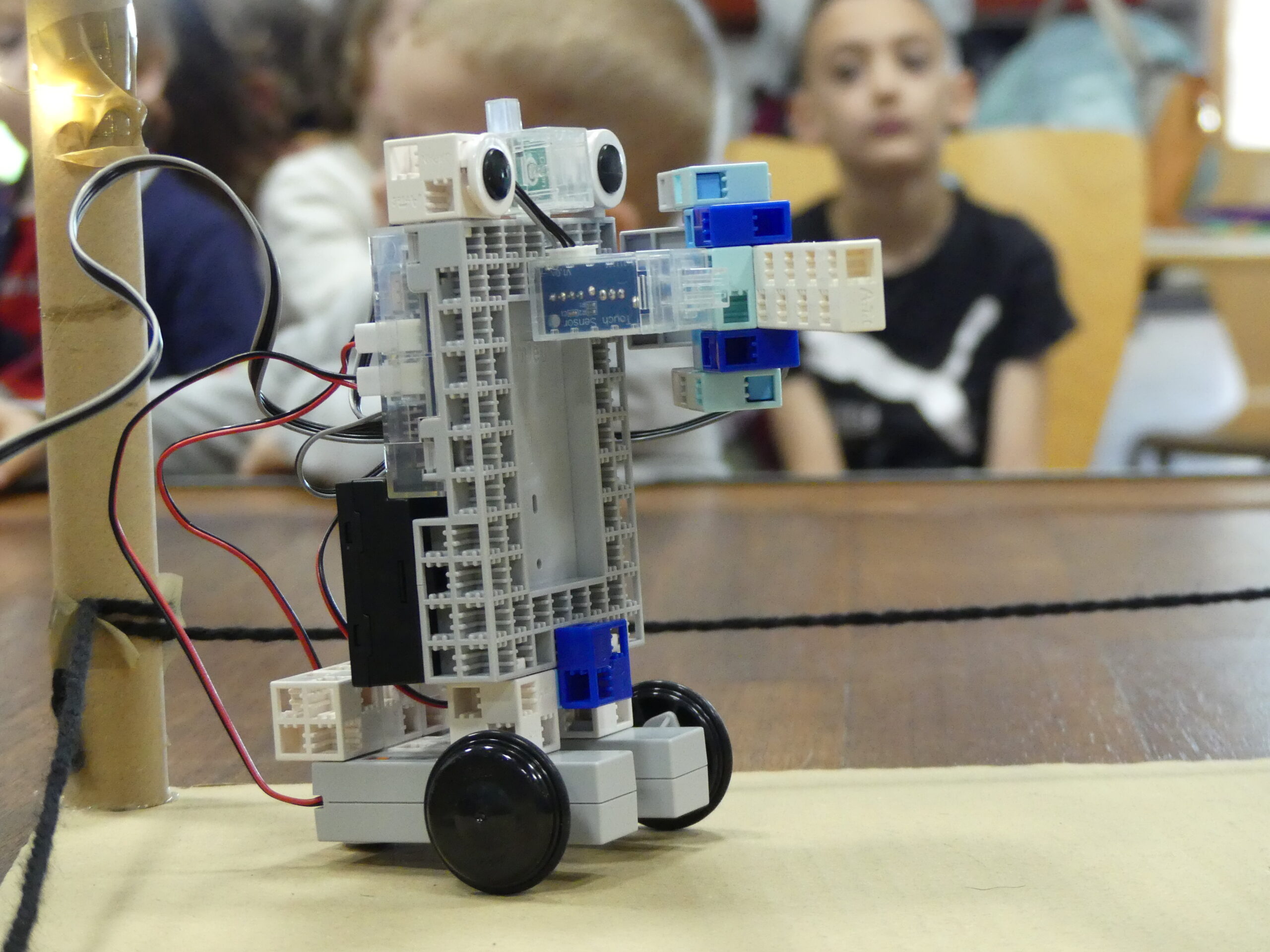 robot pédagogique en premier plan avec enfants en arrière plan